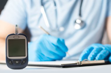 Diyabet konsepti. Doktor glukometreyi glikoz seviyesinde gösteriyor. Model.