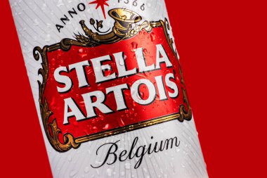 Ukrayna. Dinyeper. 20 Mart 2023: Stella Artois bira kutusu ve kırmızı zemin üzerinde yoğunlaştırılmış su damlacıkları.