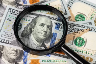 Büyüteç altında 100 dolarlık banknot..