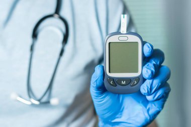 Diyabet konsepti. Doktor glukometreyi glikoz seviyesinde gösteriyor. Model.