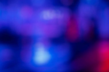Bulanık renk parlaması. Neon ışıklı arka plan. Bokeh ışıltı yansıması. Odaklanmamış mavi floresan pembe ışık soyut koyu örtüde parlıyor.