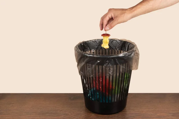 Apple core is thrown into trash, food waste