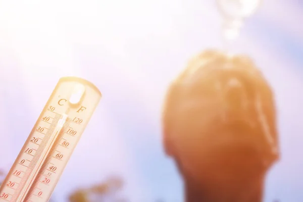 人在酷热中倒水在头上 夏日温度计显示或显示有太阳背景的高温温度 — 图库照片