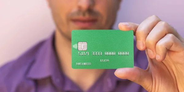 closeup of green credit card holded by hand