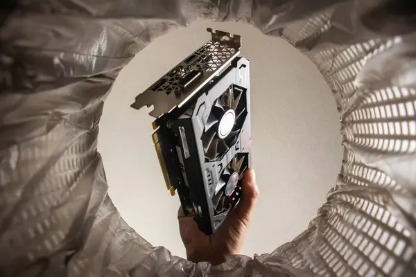throwing a video card in the trash bin, a computer video card in hand inside view trash bin