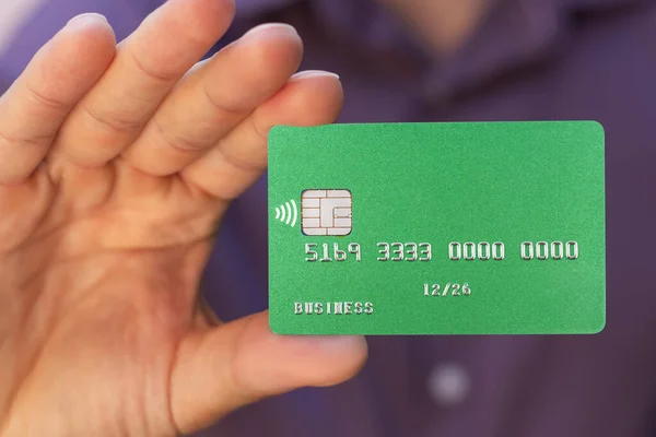closeup of green credit card holded by hand