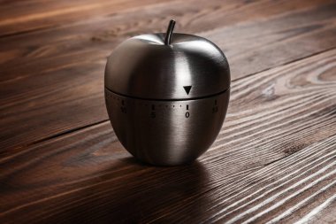 Ahşap arka planda metal elma mutfak zamanlayıcısı.