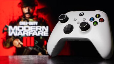 Arka planda Call of Duty Modern Warfare III oyunu ile Xbox Series S Robot White Controller bulanıklaştı: Dnipro, Ukrayna. Eylül 2023.