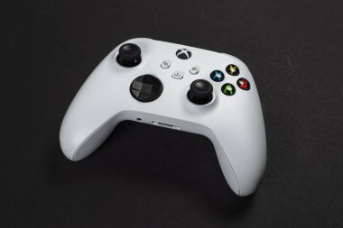 30 Ağustos 2023 - Dnipro, Ukrayna: Beyaz kontrolcü xbox serisi S oyun alanı, karanlık arka planda oyun konsolu. Bilgisayar oyunu yarışması video oyunu denetimi kavramı.