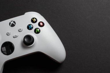 30 Ağustos 2023 - Dnipro, Ukrayna: Beyaz kontrolcü xbox serisi S oyun alanı, karanlık arka planda oyun konsolu. Bilgisayar oyunu yarışması video oyunu denetimi kavramı.