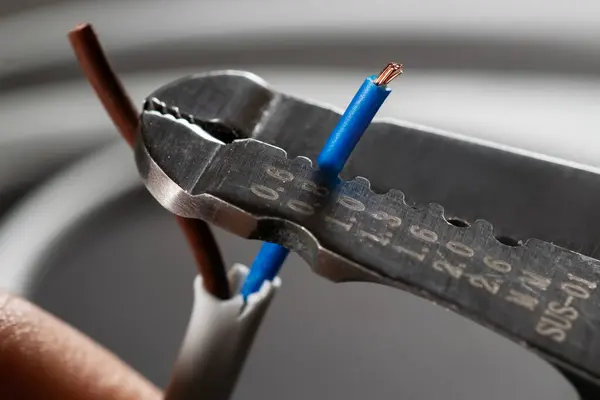 Close-up of a stripped ground wire by a wire stripper.