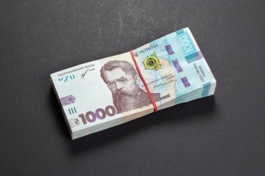 Masada bir paket Hryvnias var. Finansal konsept. Ukrayna parası. Koyu arkaplanda 1000 hryvnia