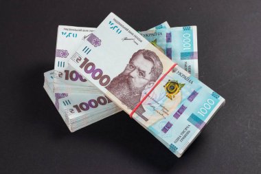 Masada bir paket Hryvnias var. Finansal konsept. Ukrayna parası. Koyu arkaplanda 1000 hryvnia