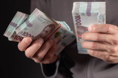Ukrayna parası elinde tutan adam 1000 Hryvnia banknotu. Yakın çekim.