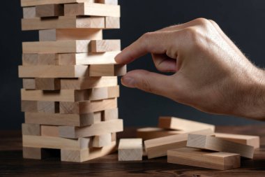 Yakından gelen adam, tahta bloklardan kuleye doğru bir blok git..