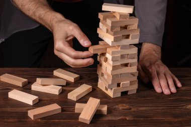 Planlama, risk ve iş, iş adamı ve mühendis bir kule üzerinde ahşap blok yerleştirme kumar strateji.