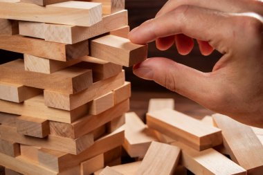 Yakından gelen adam, tahta bloklardan kuleye doğru bir blok git..