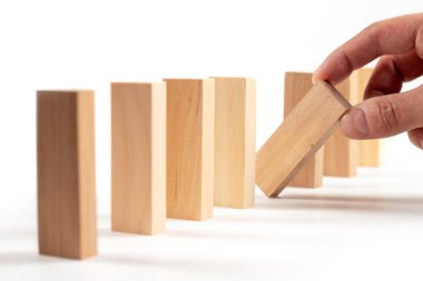 İş hayatında insan eli planlama, risk ve stratejiyi kapatın. Kumarbaz, kopya alanı olan bir kuleye tahta blok yerleştiriyor.