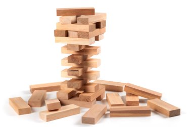 A game of logic and the ability to think. Jenga tower with wooden blocks on a white background. The tower is half dismantled