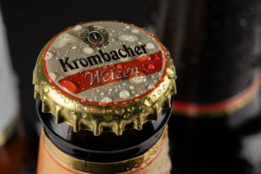 Dnipro, Ukrayna, 18 Ekim 2023: Krombacher buğday birası şişeleri ve siyah arka planda damlalar. Weizen Pils koyu bira. Krombacher bira fabrikası 1803 'te Almanya' da kuruldu.