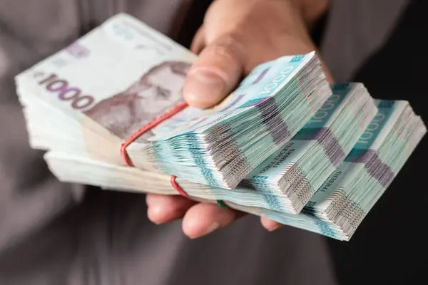 Adam elinde iki demet Hryvnia tutuyor. Ukrayna parası. İş konsepti. 1000 Hryvnia banknotları.