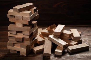 Koyu arkaplanda tahta bloklardan yapılmış Jenga kulesi, metin için boşluk.