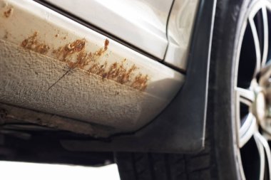 Paslı ve aşınmış bir araba, yol tuzu yüzünden hasar görmüş..