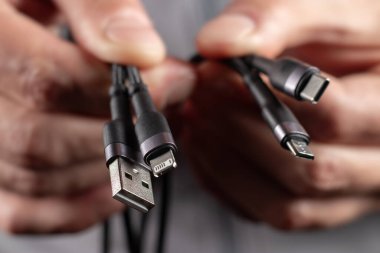 USB bağlantısından mikro USB, mini USB ve diğer bağlayıcılara evrensel adaptör kablosu tutan eller.