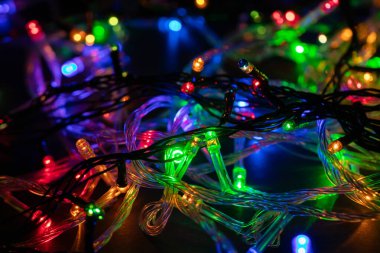 Işıklı ve bedava metin alanlı bir Noel arkaplanı. Noel ışıkları sınırda. Ahşap arka planda parıldayan renkli Noel ışıkları. Yeni yıl. Noel zamanı. Dekorasyon. Çelenk.