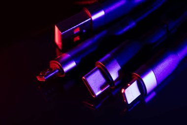 Koyu arkaplanda farklı USB şarj prizleri. USB tip C, Micro USB, Usb yıldırımı.