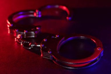 Polis arabasıyla gece kaldırımda kelepçelenmiş, yüksek kontrastlı görüntüler var..