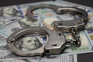 Amerikan doları ve kelepçe, yolsuzluk, kirli para ya da mali suçlar kavramı.