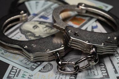 Amerikan doları ve kelepçe, yolsuzluk, kirli para ya da mali suçlar kavramı.