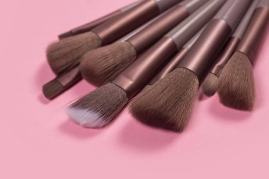 Pembe arka planda profesyonel makyaj fırçası.