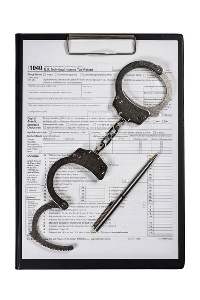 Handcuffs over Tax forms, concepts: Tax fraud or Slave to the Taxes.