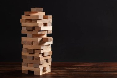 Koyu arkaplandaki tahta bloklardan yapılmış kule, metin için boşluk.