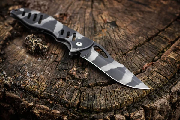 Ahşap arka planda taktik bıçağı..