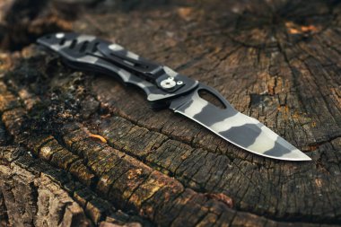 Ahşap arka planda katlanan bıçak. EDC bıçağı