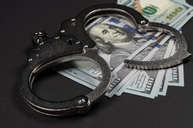 Amerikan doları ve kelepçe, yolsuzluk, kirli para ya da mali suçlar kavramı.