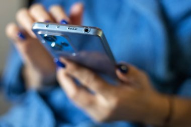 Close-up shot of woman's hands tapping on a mobile phone screen. clipart