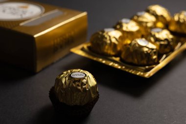 Dinyeper. Ukrayna 03.01.2024: Ferrero Rocher çikolatası ve fındıklı şekerleme topları. Ferrero Rocher tatlı bir çikolatadır. Altın ambalajlı çikolatalı şekerler. Lüks Tasarım