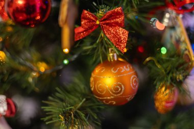 Yeni yıl oyuncağı. Bulanık, ışıl ışıl ve muhteşem bir arka planda dekore edilmiş Noel ağacı. Garland ve Bokeh. Parlak Işıklar. odağını kaldır