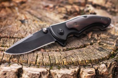 Ahşap arka planda katlanan bıçak. EDC bıçağı