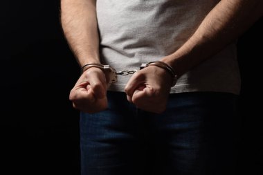 Önünde kelepçelenmiş bir suçlu. Cinayetten tutuklusun..