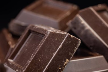 Koyu çikolata yığını, cips ve toz. Yakın çekim..