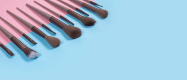 Kozmetik ve güzellik. Mavi arkaplanda makyaj fırçaları ayarlandı.