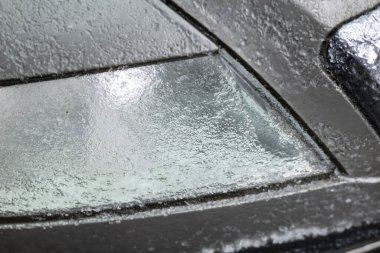 Buz saçakları ve kar mevsiminde donmuş araba farları, araba sigortası için tehlikeli hava şartları ve kar fırtınası sonrası trafiği olan buzlu yollar ve karlı sokakları gösteriyor..