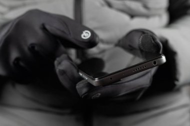 Siyah termal eldivenli eller kışın akıllı telefon kullanırlar..