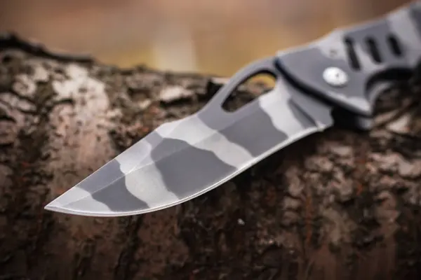military tactical knife on tree in the forest.