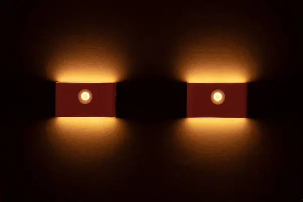 Modern wall lamps is lighting on the dark wall. backlit, night decorative lamp.